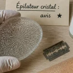 Epilateur cristal avis : gomme dépilatoire en verre et rasoir sur table